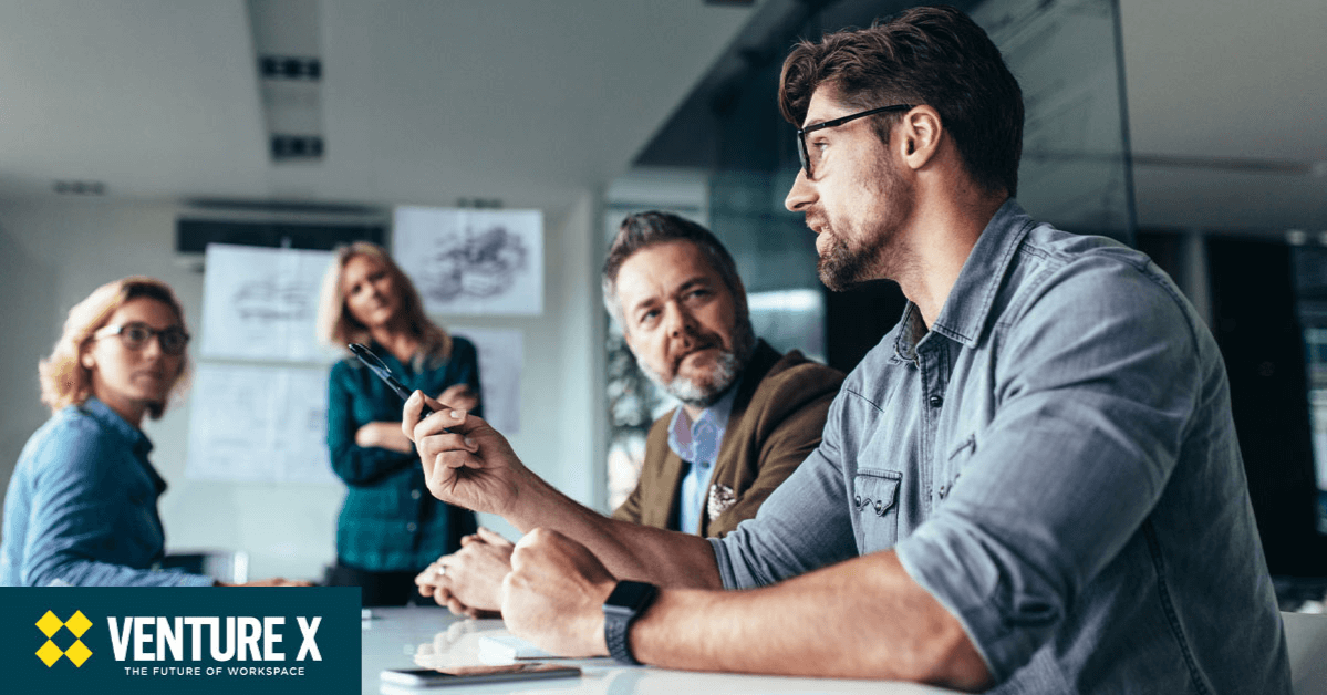 A group of four people engaged in a discussion in a modern office setting