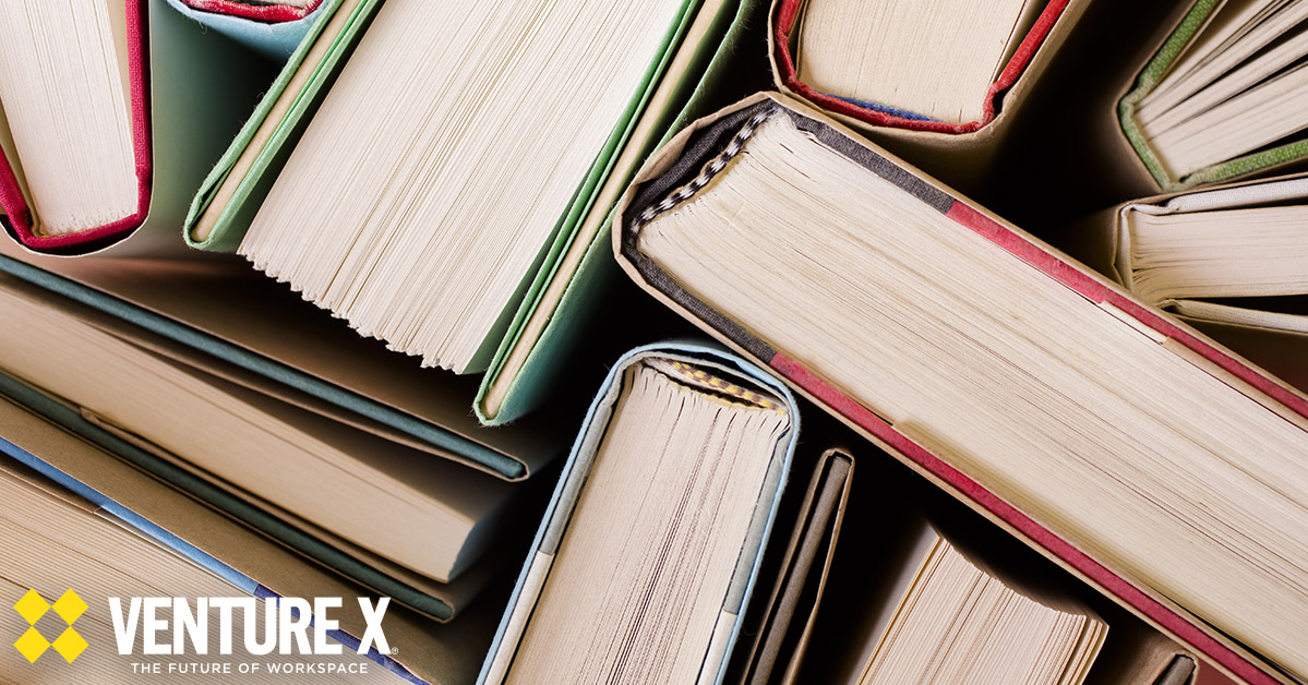 A top view of several hardcover books with visible spines and pages