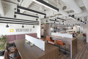Coworking desks and kitchen space inside a Venture X location